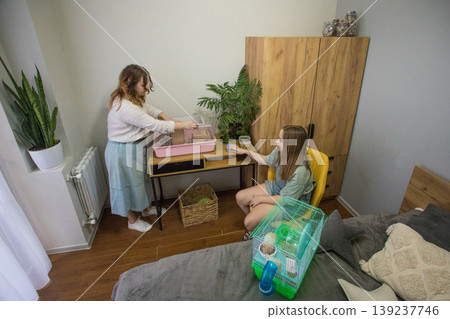 Two people are cleaning a hamster cage. Two people are cleaning a hamster cage. 139237746