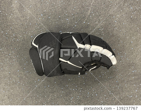 a hockey glove on the floor in a sports locker room a hockey glove on the floor in a sports locker room 139237767