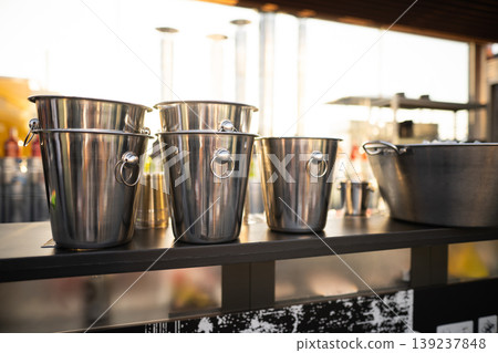 metal ice bucket on bar counter in sunlight metal ice bucket on bar counter in sunlight 139237848