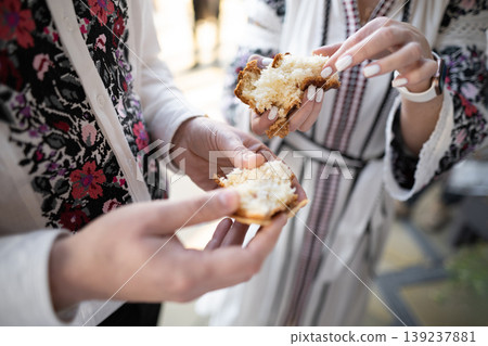 breaking bread in traditional embroidered clothes during a wedding ceremony in Ukraine breaking bread in traditional embroidered clothes during a wedding ceremony in Ukraine 139237881
