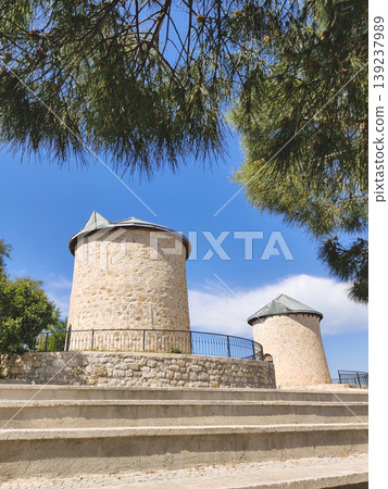 Historical stone windmills with conical roofs on a hill in Alacati Turkey Historical stone windmills with conical roofs on a hill in Alacati Turkey 139237989