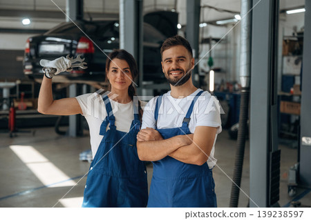 Professional tools in hand. Auto repair shop employees are working together. Man and woman Professional tools in hand. Auto repair shop employees are working together. Man and woman 139238597