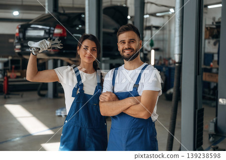 Professional tools in hand. Auto repair shop employees are working together. Man and woman Professional tools in hand. Auto repair shop employees are working together. Man and woman 139238598