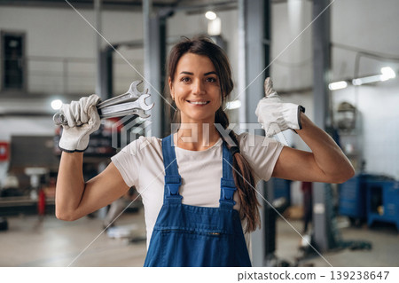 Front view. Female mechanic is working in the modern car workshop Front view. Female mechanic is working in the modern car workshop 139238647