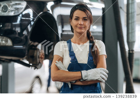Arms crossed, standing and posing. Female mechanic is working in the modern car workshop Arms crossed, standing and posing. Female mechanic is working in the modern car workshop 139238839