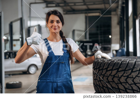 Smiling and showing thumb up. Female mechanic is working in the modern car workshop Smiling and showing thumb up. Female mechanic is working in the modern car workshop 139238866