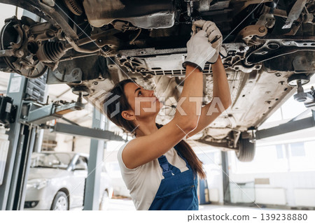 Female mechanic is working in the modern car workshop 139238880