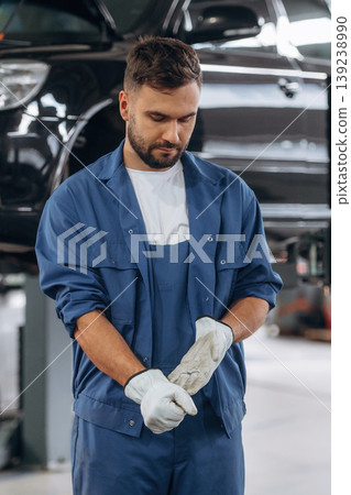 Vehicle is hanging up high. Male mechanic is working in the modern car workshop Vehicle is hanging up high. Male mechanic is working in the modern car workshop 139238990