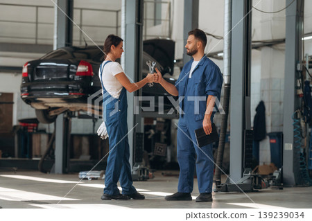 Auto repair shop employees are working together. Man and woman Auto repair shop employees are working together. Man and woman 139239034