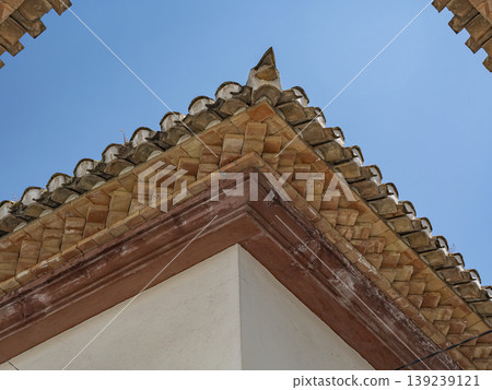 Mediterranean Terracotta Roof Corner With Traditional Clay Tiles And Stucco Wall Against Blue Sky Mediterranean Terracotta Roof Corner With Traditional Clay Tiles And Stucco Wall Against Blue Sky 139239121