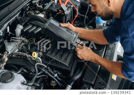 Electronics testing, checking. Male mechanic is working in the modern car workshop Electronics testing, checking. Male mechanic is working in the modern car workshop 139239341
