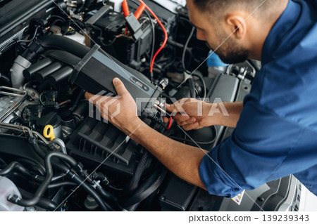 Electronics testing, checking. Male mechanic is working in the modern car workshop Electronics testing, checking. Male mechanic is working in the modern car workshop 139239343