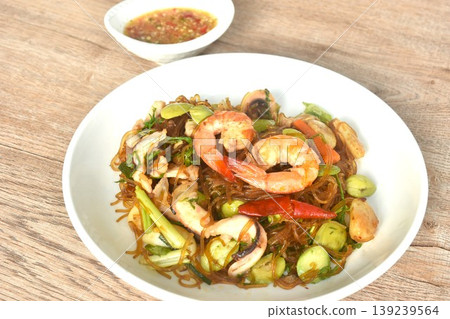 stir-fried glass noodles with three stinky vegetables and shrimp couple squid on plate dipping spicy chili sauce 139239564