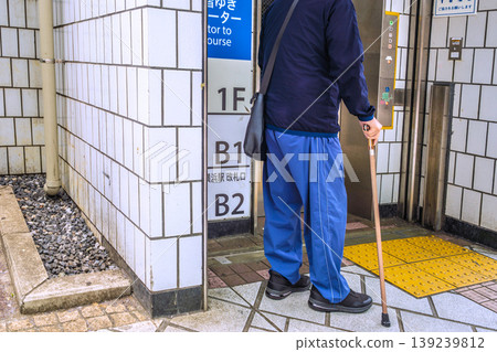 Barrier-free urban landscape in Yokohama, Japan... An elderly man with a cane waits for the elevator to the ticket gate level... = Yokohama City Barrier-free urban landscape in Yokohama, Japan... An elderly man with a cane waits for the elevator to the ticket gate level... = Yokohama City 139239812