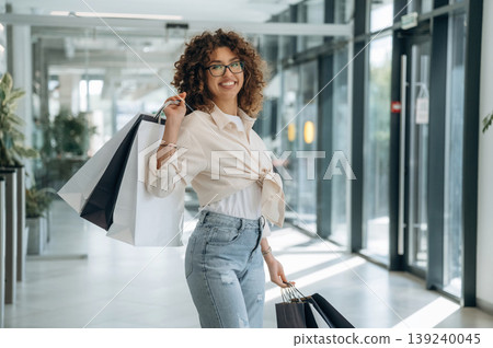 Smiling, feeling good. Woman is with shopping bags indoors in the supermarket Smiling, feeling good. Woman is with shopping bags indoors in the supermarket 139240045
