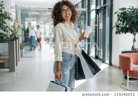 Customer is happy. Woman is with shopping bags indoors in the supermarket Customer is happy. Woman is with shopping bags indoors in the supermarket 139240053