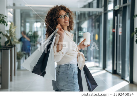 Woman is with shopping bags indoors in the supermarket Woman is with shopping bags indoors in the supermarket 139240054