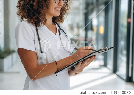 Professional nurse. Woman doctor is standing indoors in the clinic Professional nurse. Woman doctor is standing indoors in the clinic 139240070