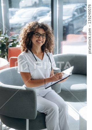 Clinic and healthcare conception. Woman doctor is standing indoors in the clinic 139240076