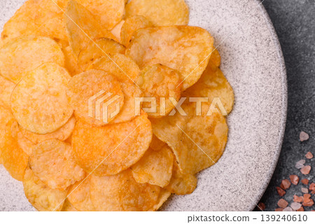 Crispy potato chips, golden slices seasoned with salt and spices. Potato chips Crispy potato chips, golden slices seasoned with salt and spices. Potato chips 139240610
