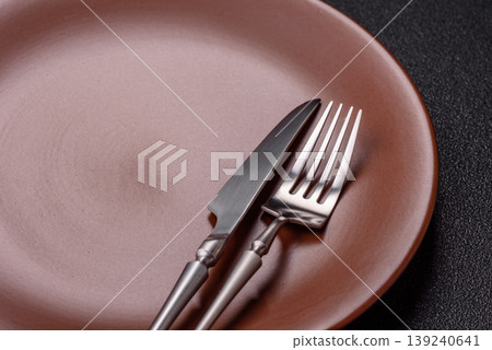 An empty ceramic round plate, kitchen utensils for a dinner table. An empty plate An empty ceramic round plate, kitchen utensils for a dinner table. An empty plate 139240641