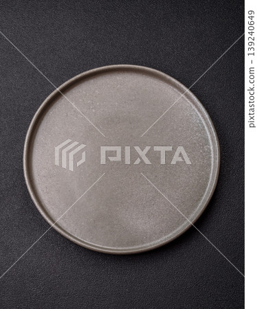 An empty ceramic round plate, kitchen utensils for a dinner table. An empty plate An empty ceramic round plate, kitchen utensils for a dinner table. An empty plate 139240649