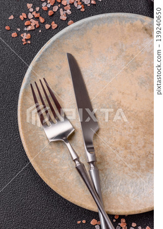 An empty ceramic round plate, kitchen utensils for a dinner table. An empty plate An empty ceramic round plate, kitchen utensils for a dinner table. An empty plate 139240650