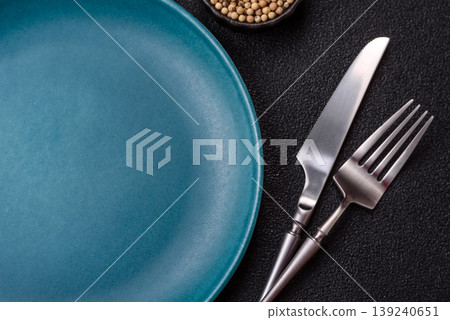 An empty ceramic round plate, kitchen utensils for a dinner table. An empty plate 139240651