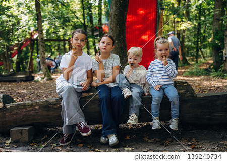Eating ice cream. Group of kids are having fun together in the park Eating ice cream. Group of kids are having fun together in the park 139240734