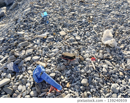 The pebble beach is littered with trash thrown from the sea The pebble beach is littered with trash thrown from the sea 139240939