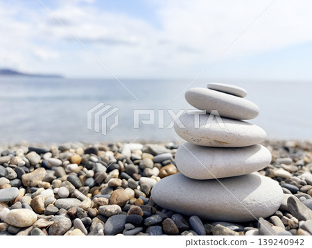 Stack of round smooth stones on a seashore, sunny day. Calm nature banner Stack of round smooth stones on a seashore, sunny day. Calm nature banner 139240942