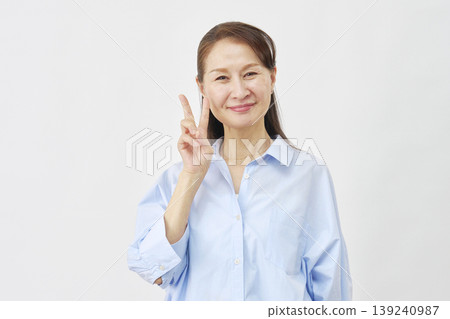 A woman making a peace sign on a white background A woman making a peace sign on a white background 139240987