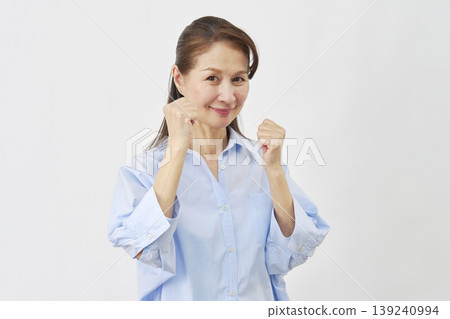 A woman striking a fighting pose against a white background. A woman striking a fighting pose against a white background. 139240994