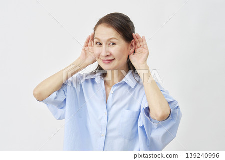 Woman listening intently on white background Woman listening intently on white background 139240996