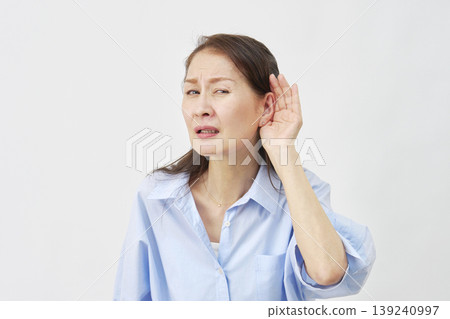 Elderly woman holding her hand over her ear on a white background 139240997