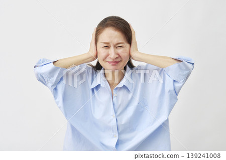 Elderly woman covering her ears on a white background Elderly woman covering her ears on a white background 139241008