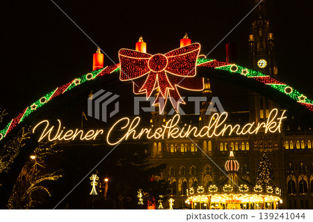 Wiener Christkindlmarkt neon sign with festive red bow. Beautiful Christmas Card in Vienna. Wiener Christkindlmarkt neon sign with festive red bow. Beautiful Christmas Card in Vienna. 139241044