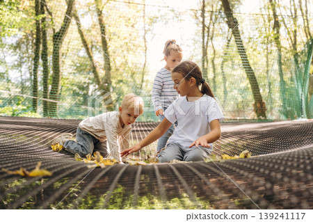 Kids are playing on the children's amusement ropes course Kids are playing on the children's amusement ropes course 139241117