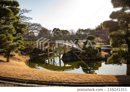 冬日式庭園中的一座木橋,在池塘中映出如鏡的倒影。 冬日式庭園中的一座木橋,在池塘中映出如鏡的倒影。 139241351
