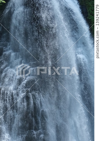 A close-up of the powerful waterfall's flow and spray – a dynamic and refreshing scene of a valley in early summer. A close-up of the powerful waterfall's flow and spray – a dynamic and refreshing scene of a valley in early summer. 139241779