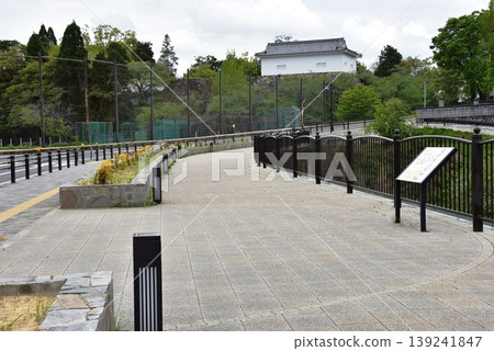 三重縣:龜山城遺址護城河(外護城河)沿岸的步道、龜山城舊多層塔樓、旅遊資訊牌和新鮮的綠植。 三重縣:龜山城遺址護城河(外護城河)沿岸的步道、龜山城舊多層塔樓、旅遊資訊牌和新鮮的綠植。 139241847