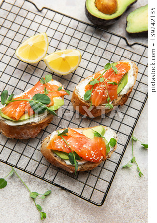 Salmon avocado toasts with microgreens and sesame seeds 139242135