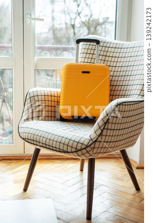 Yellow suitcase on armchair ready for travel Yellow suitcase on armchair ready for travel 139242173
