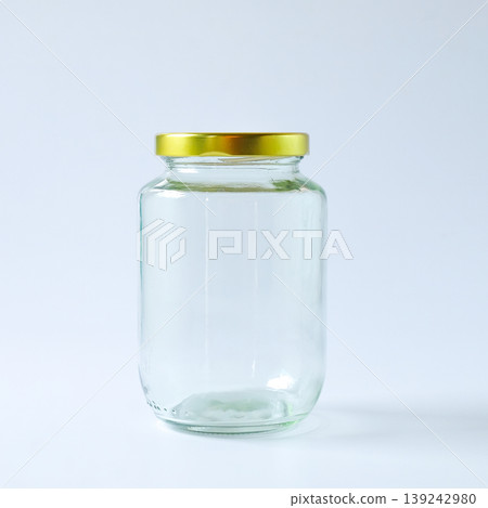 A glass storage jar with a gold metallic lid. A glass storage jar with a gold metallic lid. 139242980