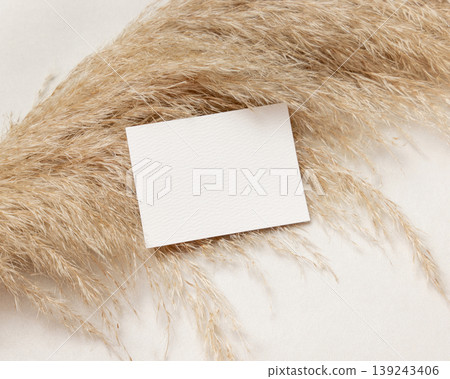 Blank horizontal card mockup on pampas grass and beige stone top view, boho wedding stationery Blank horizontal card mockup on pampas grass and beige stone top view, boho wedding stationery 139243406