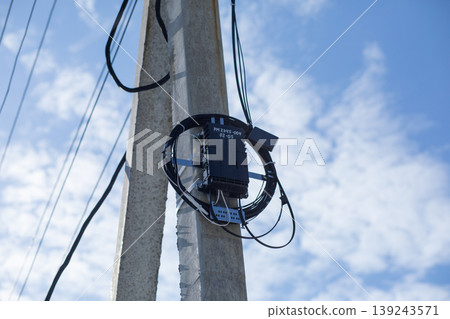 Fiber optic distribution box mounted on concrete utility pole. Telecommunication equipment for broadband internet connection. Infrastructure for data transmission and network service. Fiber optic distribution box mounted on concrete utility pole. Telecommunication equipment for broadband internet connection. Infrastructure for data transmission and network service. 139243571