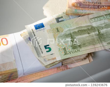 Stack of international banknotes including euro and chinese yuan currency. Global finance and trade concept. Economic exchange, investment, capital management and world money market. Stack of international banknotes including euro and chinese yuan currency. Global finance and trade concept. Economic exchange, investment, capital management and world money market. 139243676