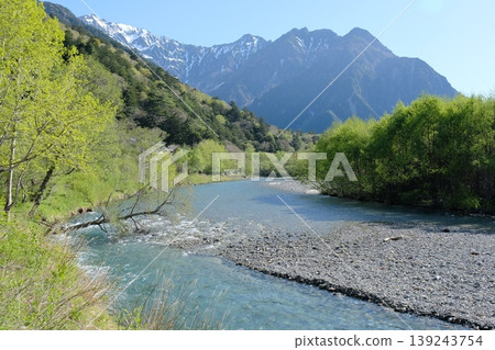 清澈的梓川河水,周圍環繞著翠綠的植物,春天的上高地山巒景色秀麗,雪水融化後奔流而下。 清澈的梓川河水,周圍環繞著翠綠的植物,春天的上高地山巒景色秀麗,雪水融化後奔流而下。 139243754