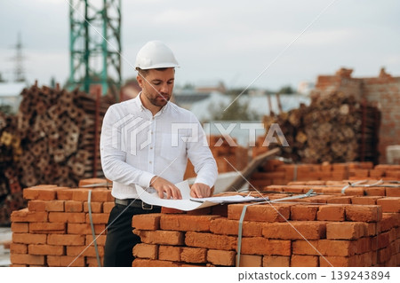 A builder is working at the construction site at daytime A builder is working at the construction site at daytime 139243894