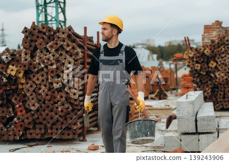 Going forward, walking. A builder is working at the construction site at daytime Going forward, walking. A builder is working at the construction site at daytime 139243906